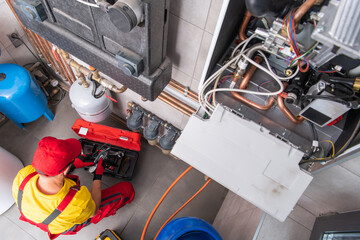 Residential Heating Systems Technician Performing Maintenance