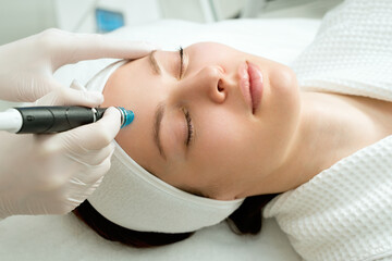 A woman receives laser treatment of the face in a cosmetology clinic, a concept of skin rejuvenation is being developed. laser peeling