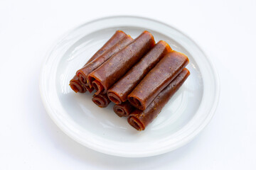 Dried mango paste on white plate on white background.