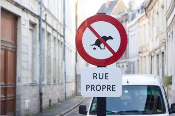 Traffic sign with a crossed defecating dog with the words "rue propre" which in French means "clean street". Valenciennes, France. Shot in 2017.