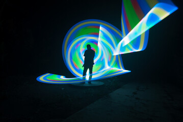 One person standing alone against beautiful color circle LED light painting as the backdrop