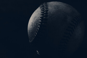 Dark and moody baseball ball on monochrome blue background