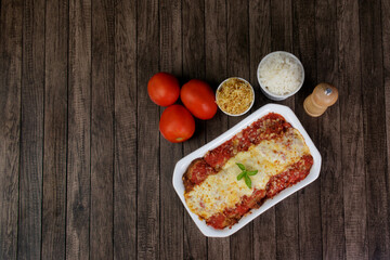 Steak Parmegiana or Parmegian Filet, made with breaded steak, red tomato sauce, mozzarella and parmesan cheese. White Rice and Potato Straw. Top view photo with free space for texts.