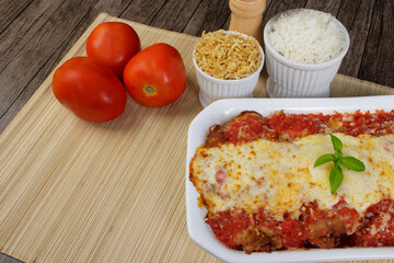 Steak Parmegiana or Parmegian Filet, made with breaded steak, tomato sauce, mozzarella cheese and parmesan au gratin. White rice and potato straw. Gourmet top view photo with free space for text.