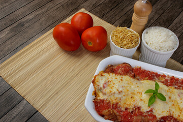 Steak Parmegiana or Parmegian Filet, made with breaded beef, tomato sauce, mozzarella cheese and gratin Parmesan. White rice and potato straw. Top view photo with free space for text.