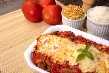 Steak Parmegiana or Parmegian Filet, made with breaded steak, tomato sauce, mozzarella cheese and parmesan au gratin. White rice and potato straw. Close-up photo of Brazilian cuisine.