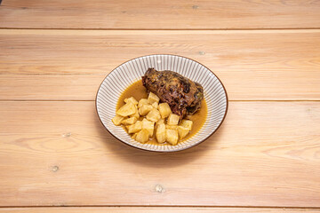 beef cheek with chips and sauce served in deep plate
