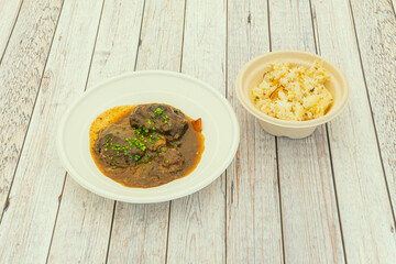 Spanish pork cheek recipe with white rice garnish in home delivery containers
