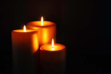 Fototapeta na wymiar Three burning golden candles background