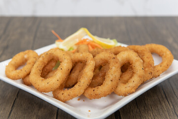 Deep fried calamari rings arranged on a plate as an appetizer for your meal