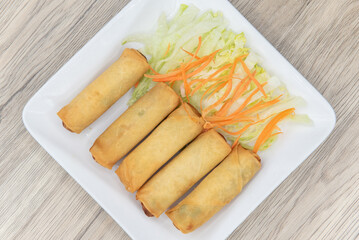 Overhead view of deep fried egg rolls arranged on a plate as an appetizer for your meal
