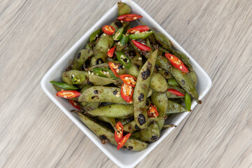 Overhead view of garlic chili edemame beans served in a bowl and an appetizer for your meal