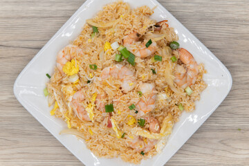 Overhead view of huge pile of fried rice topped with shrimp and vegetables on.a plate to fulfill that spicy craving