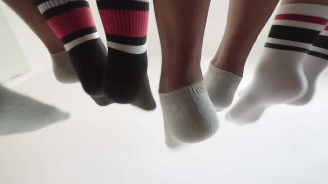 A cheerful family is sitting on the bed and playing with their feet
