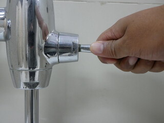 hand flushing on urinal faucet in the toilet.