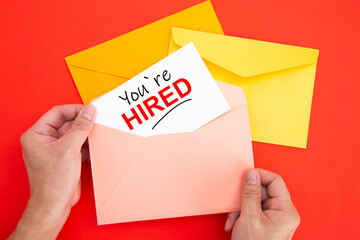 You're Hired Concepts - Hand holding a envelope and post card