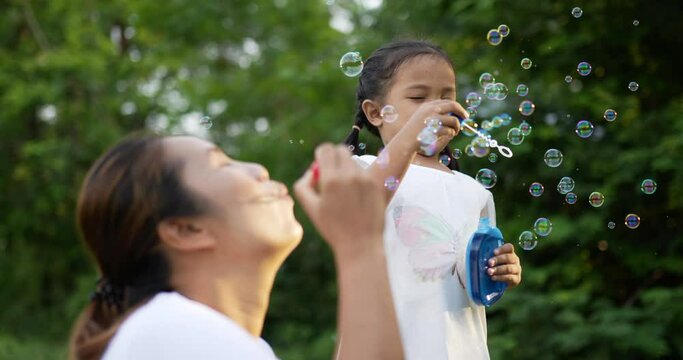 Mom and daughter blowing and catching soap bubbles