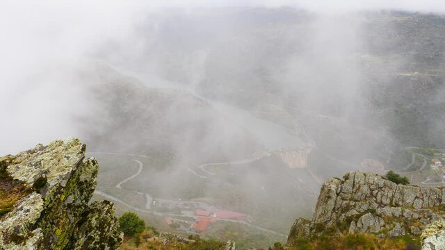 Mountain and Douro river with spanish Saucelle Dam at foggy cloudy weather. Border between Portugal and Spain. National Parks. View from portuguese Penedo Durao lookout.