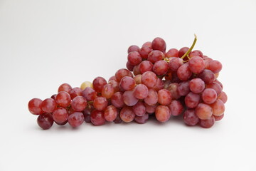 Fresh and ripe red grapes isolated in white background. Bunch of raw and juicy grapevines