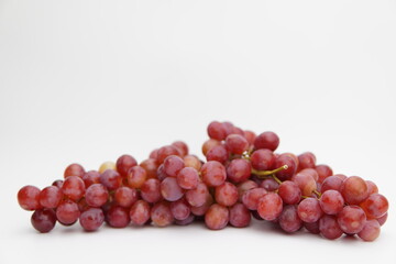 Fresh and ripe red grapes isolated in white background. Bunch of raw and juicy grapevines