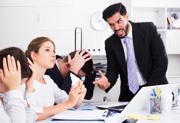Irritated boss scolding subordinates pointing out shortcomings and misses in work