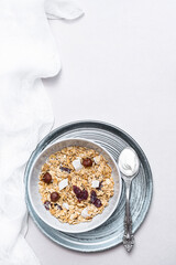 Granola with chia seeds, coconut, dry berries and yogurt in bowls on grey background, copy space. Concept of healthy breakfast menu	
