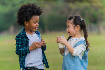 diversed mixed race friends drinking milk together for good health in park