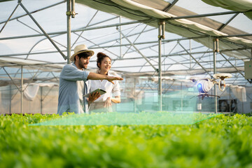 5G technology trend and smart farm agriculture concept.Farmer use ai drone and robot farmers (automation) to monitor check the health of Hydroponics plant.Agriculture drone fly for research analysis. - obrazy, fototapety, plakaty