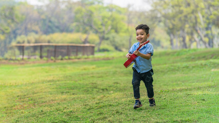 mixed race caucasian and asian boy having fun playing in park