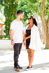 Naklejka premium Happy valentine couple walking on the street or in the square holding hands.