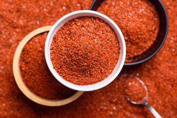 Red cayenne pepper, Chili flakes, Chili powder in a bowl and spoon, Top view