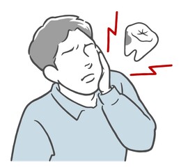 虫歯が痛くてほっぺたを押さえる若い男性