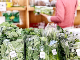 直売所で野菜を選ぶ女性