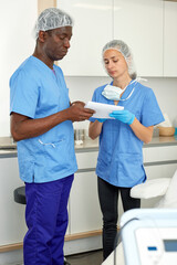 Fototapeta premium Professional cosmeticians woman and man having conversation before procedure in clinic of esthetic cosmetology