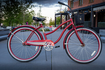 Fototapeta na wymiar Calgary Alberta Canada, May 30 2021: A ladies Huffy cruiser bicycle parked on a pathway at East Village downtown during a summer evening.