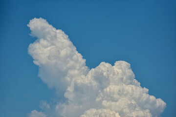 Beautiful cumulus clouds against the blue daytime sky.