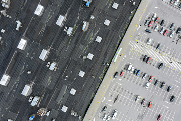 abstract aerial top view of supermarket roof and parking lot with parked cars
