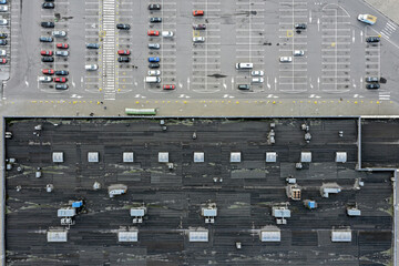 supermarket roof with ventilation system and skylights. parking lot with parked cars. aerial top view.