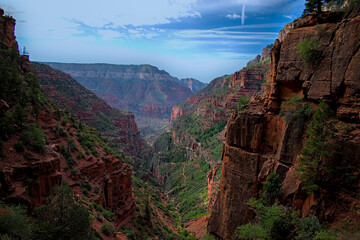 View from North rim grand canyon north kaibab trail descending switchbacks down steep terrain to reach phantom ranch at bottom.