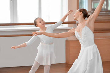 Fototapeta premium Little ballerina training with coach in dance studio