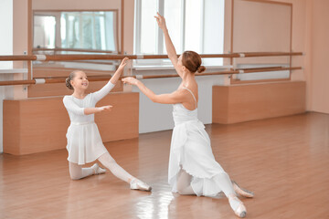 Little ballerina training with coach in dance studio