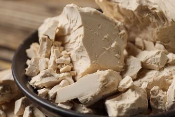 Bowl with fresh yeast on wooden background, closeup
