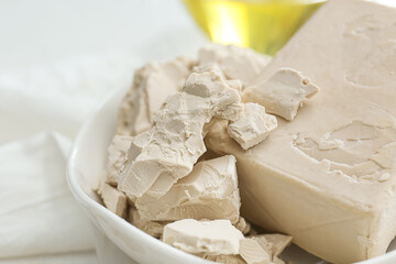 Plate with fresh yeast on light background