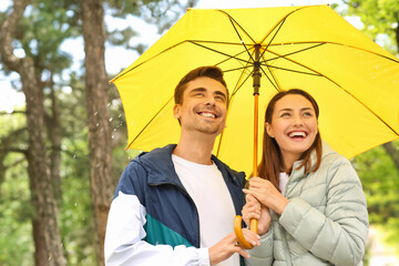Young couple with umbrella in park