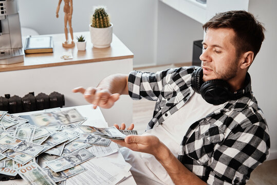 Man counts dollar banknotes at home office. Make money concept
