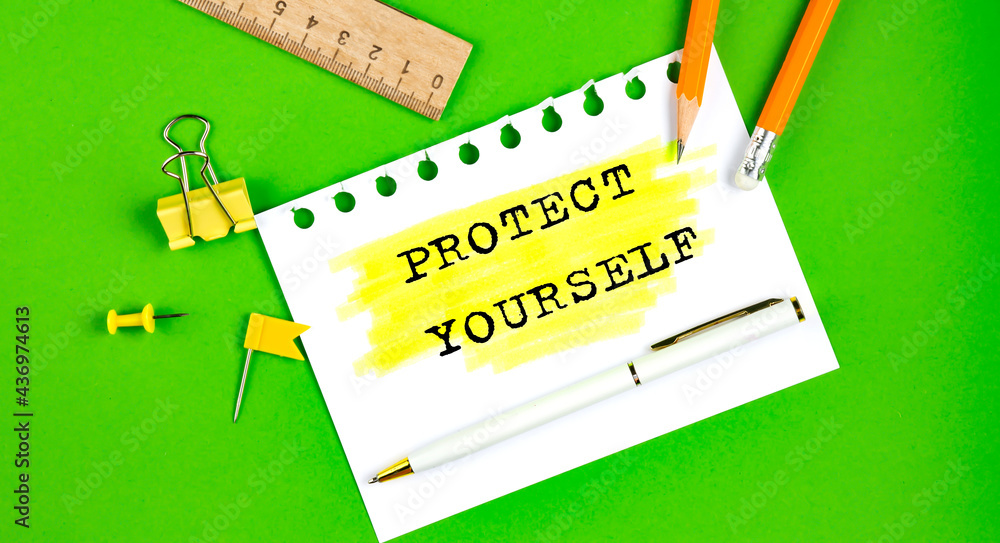Aufkleber text rotect yourself sign showing on green background with office tools