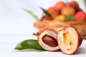 Bunch of fresh ripe lychee fruit with green leaves on white background. Exotic or tropical litchi fruit. Lichi. Copy space.