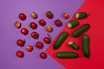 Juicy red tomato, green young cucumber with shadow on contrast red and purple background. Modern...