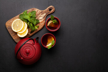 Herbal tea with mint and lemon. Tea cup and teapot