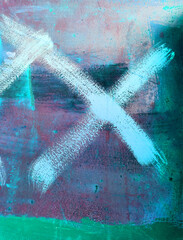 old red metal wall with corrosion and rust stained with multi-colored paint, on which the x sign is painted